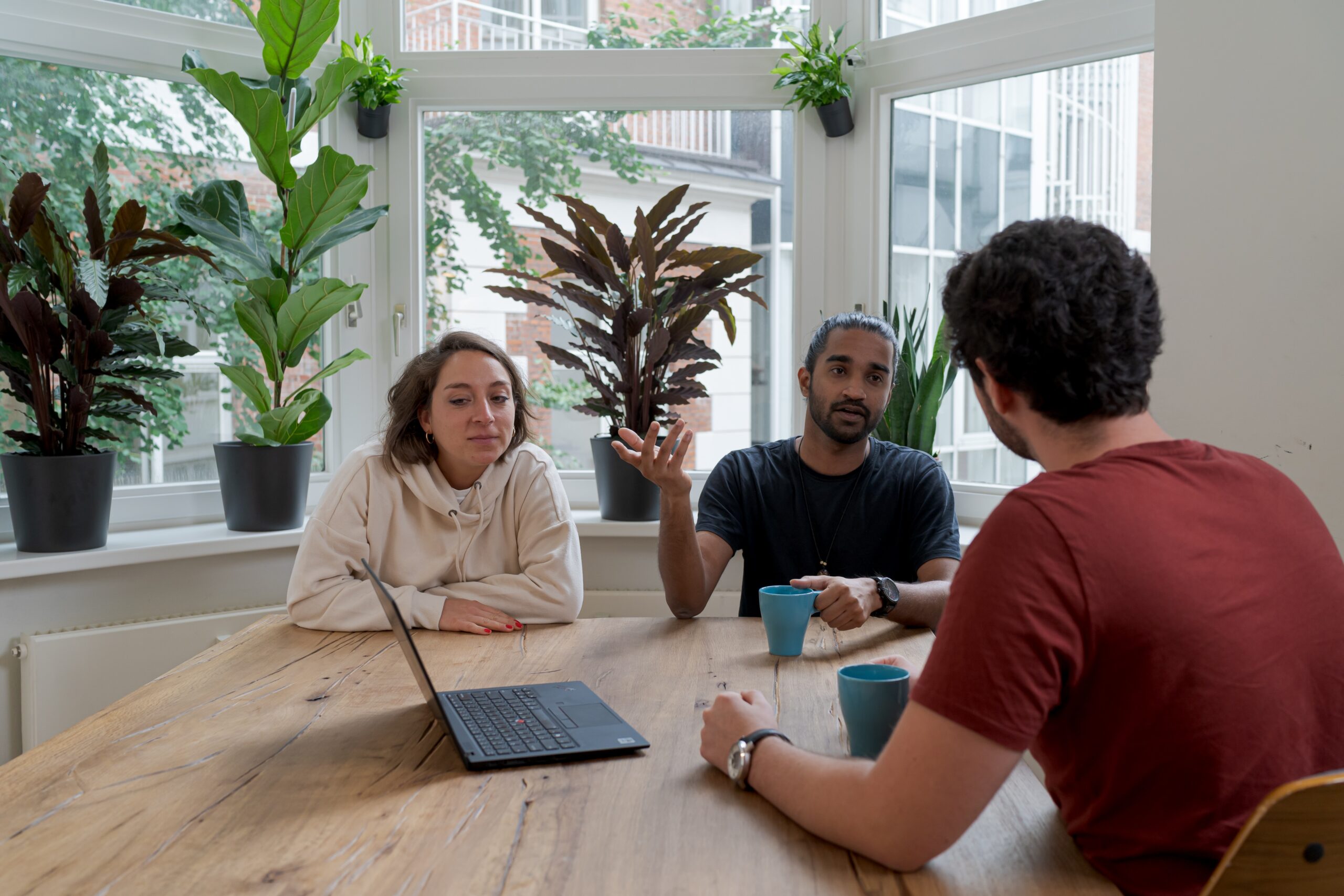 People discussing something while holding coffee in hand