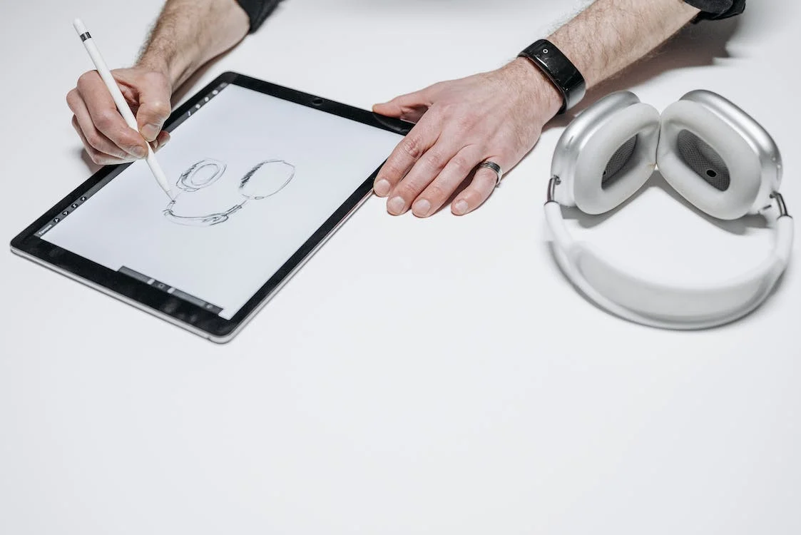 A person drawing a headphone on a tablet