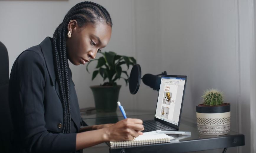 Woman of color writing something on notebook
