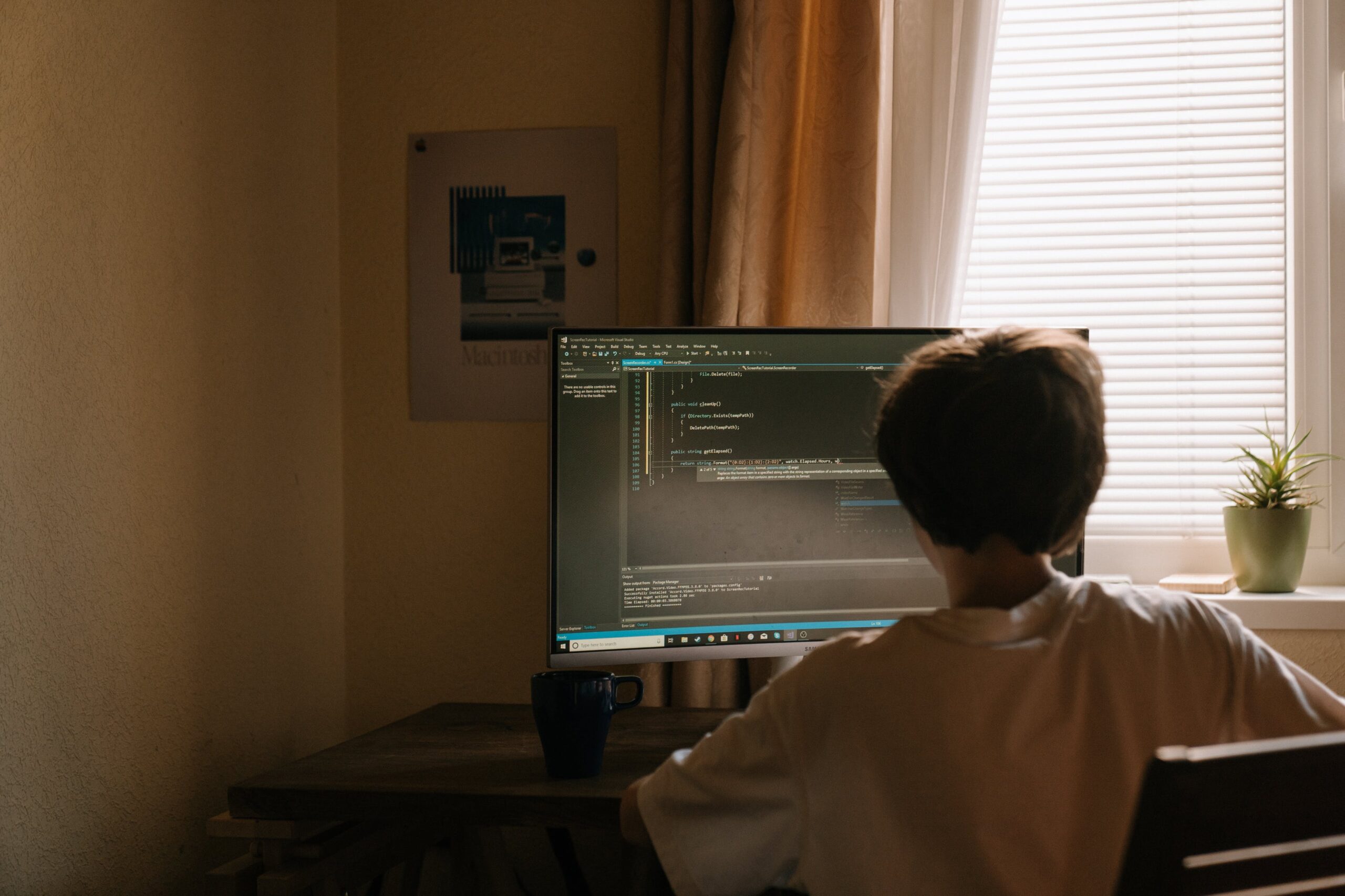 Boy in white shirt in front of a computer
