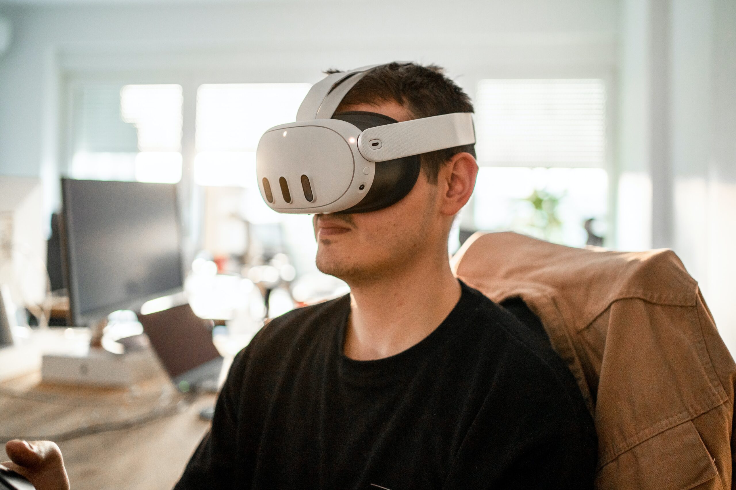 Man wearing virtual reality glasses sitting on chair